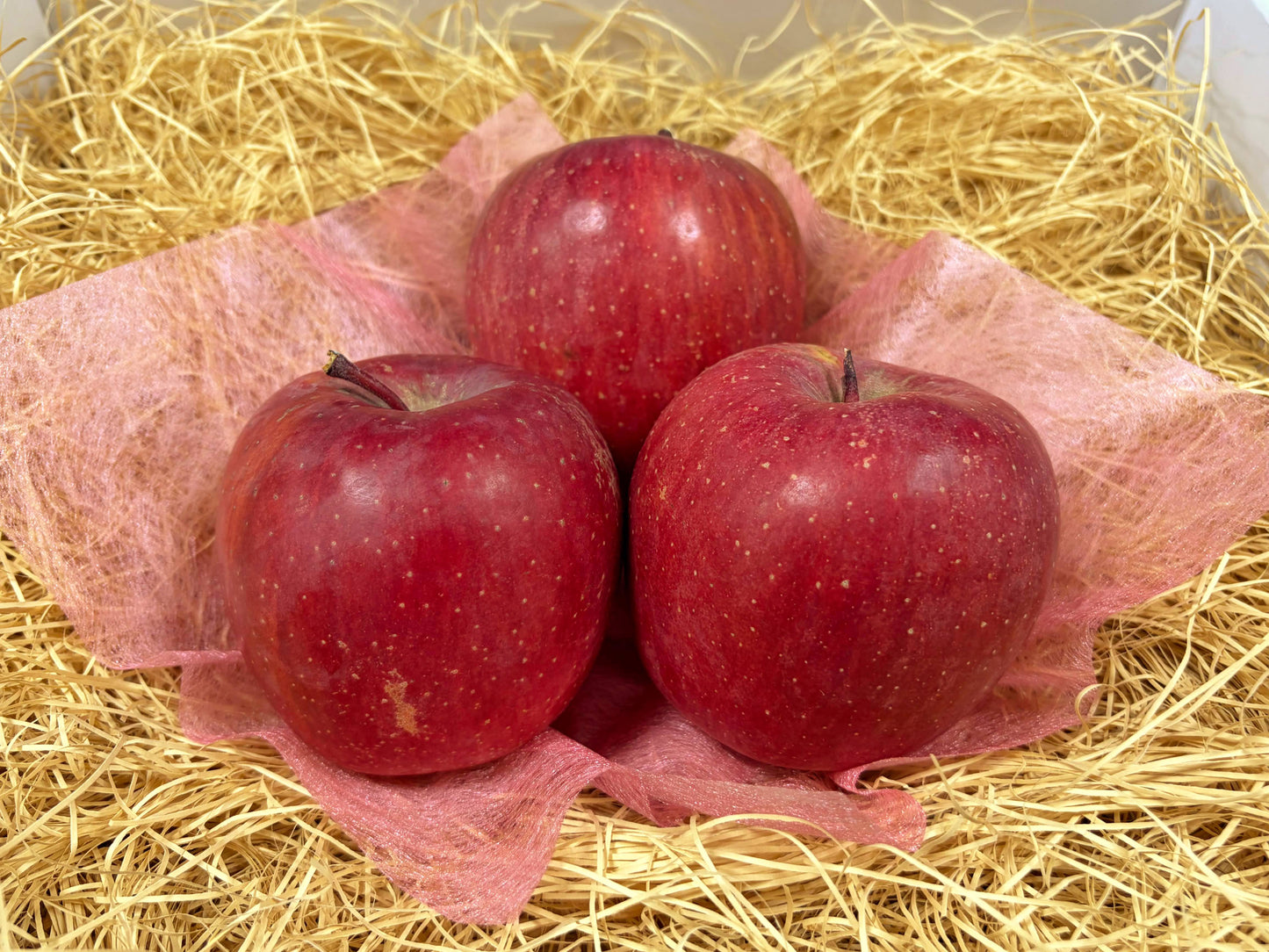 紙パッキンの上に並べられたサンふじ3個